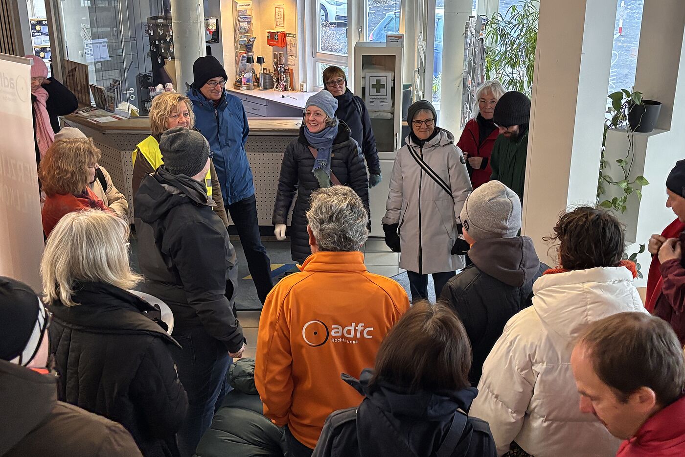 Im Eingan gbereich der Jugendherberge steht eine Gruppe von Menschen, die einer Klimastadträtin Simone Fedderke zuhören