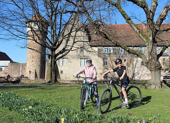 Zwei Schüler befinden sich mit ihren Fahrrädern in der historischen Altstadt
