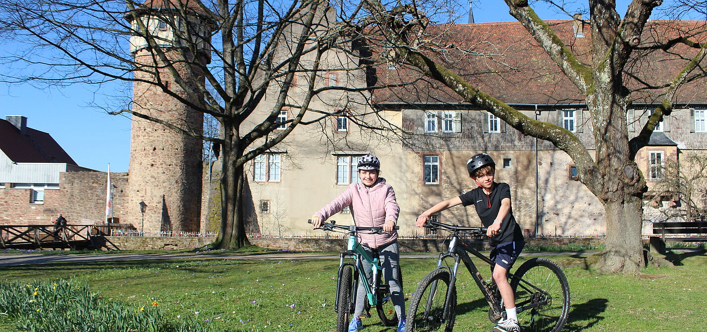 Zwei Schüler befinden sich mit ihren Fahrrädern in der historischen Altstadt